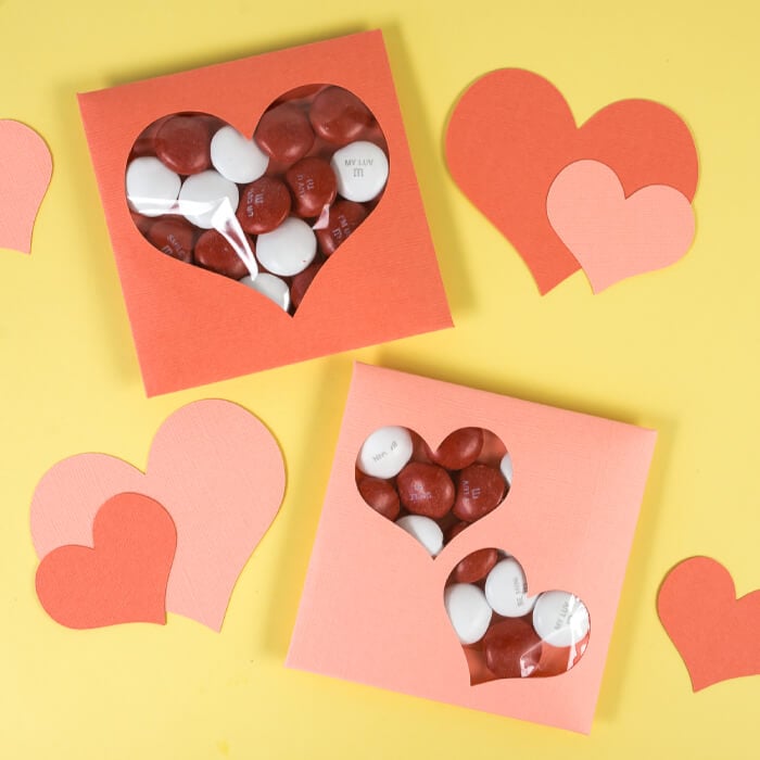 Close up of hearts cut from paper and Valentine cards filled with candy