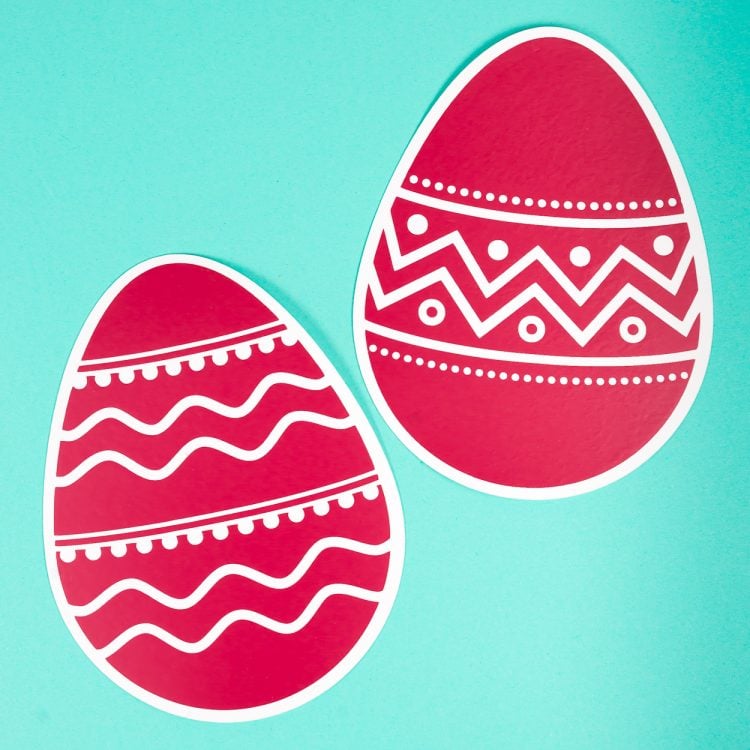 Close up of two red paper cut Easter eggs decorated with white iron-on vinyl