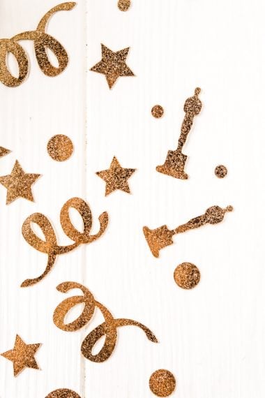 Gold glittery images of stars, dots swirls and Oscar award statues confetti
