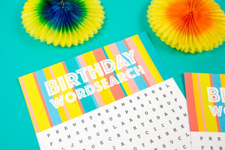 Close up of party decor next to two pieces of paper that have Birthday Wordsearch on them