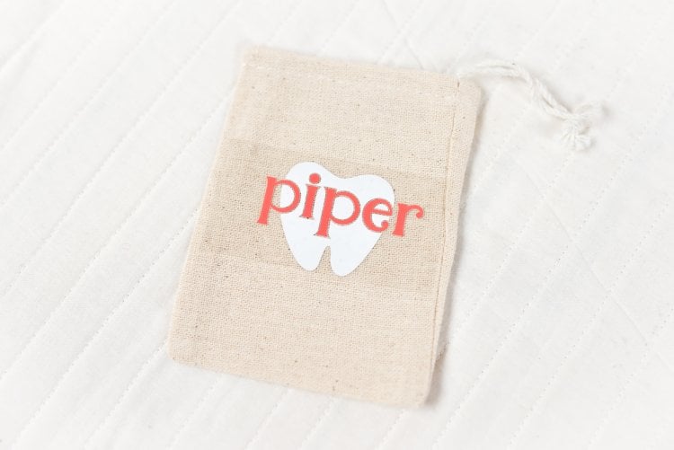 A close up of a small tan pouch, and the word piper and the image of a tool on transfer tape