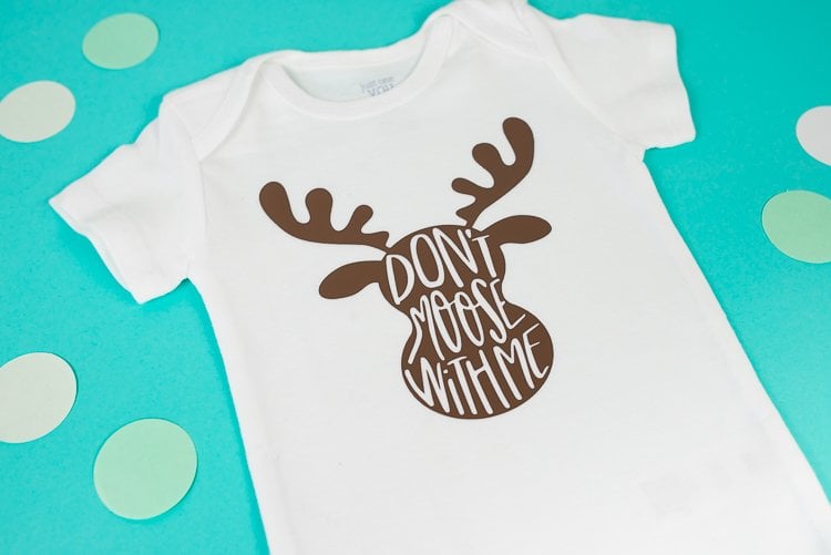 Close up of paper polka dots around a white onesie that has an image on a moose on it and the saying, \"Don\'t Moose with Me\"