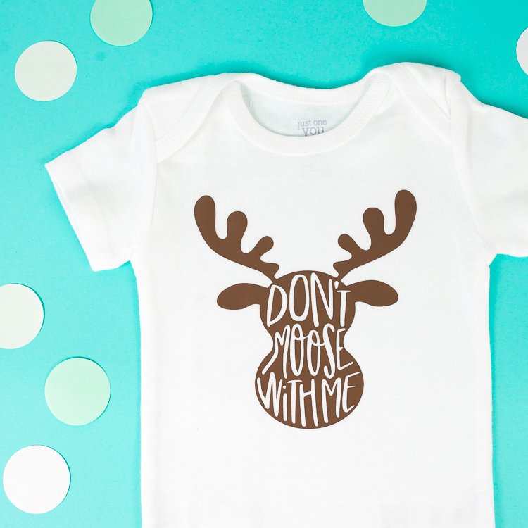 A white onesie decorated with an image of a moose head that says, \"Don\'t Moose with Me\"
