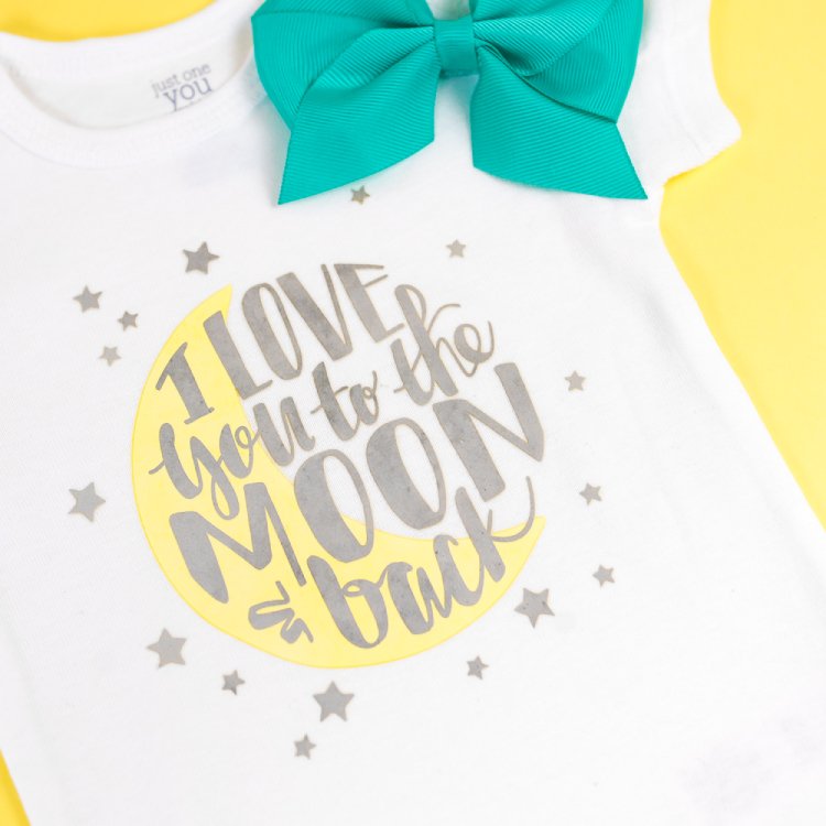 An aqua baby hair bow and a white onesie decorated with silver stars and a moon with the saying, \"I Love You to the Moon and Back\"