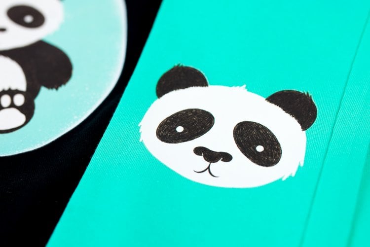 Close up of a panda on a piece of aqua colored material