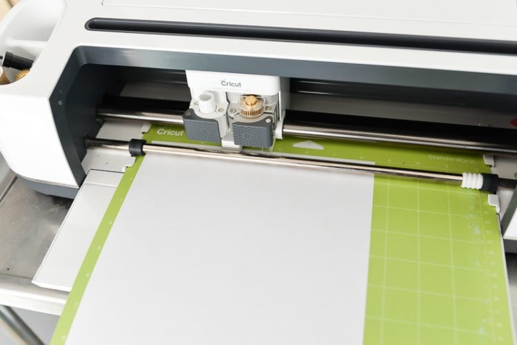 A Cricut machine with a loaded green mat