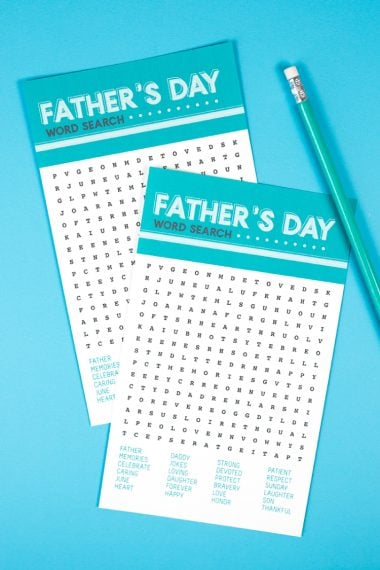 A pencil and two pieces of paper that have a Father's Day word search printed on them