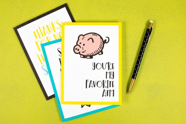 A pencil and a greeting card with a piggy bank on it and the saying, \"You\'re My Favorite ATM\"