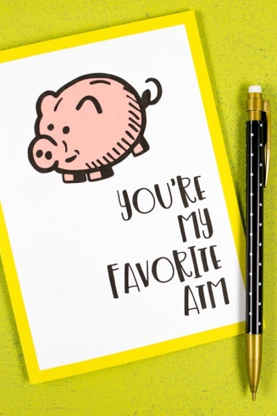 A pencil and a greeting card with a piggy bank on it and the saying, "You're My Favorite ATM"