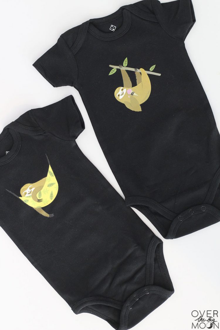 Two black onesies decorated with sloth images