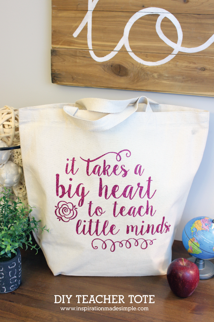 An apple, a small world globe and a plant next to a canvas bag that says, \"It Takes a Big Heart to Teach Little Minds\"