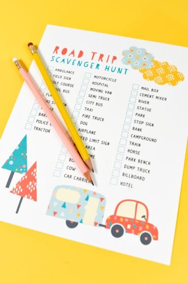 Two pencils on top of a sheet of paper that lists items for a road trip scavenger hunt