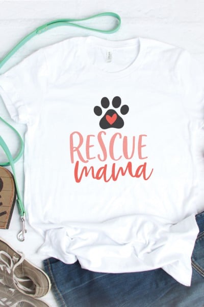 Tennis shoes, blue jeans, a dog leash and a white t-shirt decorated with a dog's paw print and the text "Rescue Mama"