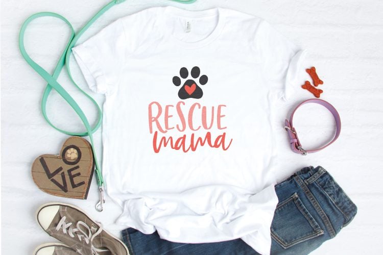 Tennis shoes, blue jeans, a dog leash and a white t-shirt decorated with a dog\'s paw print and the text \"Rescue Mama\"