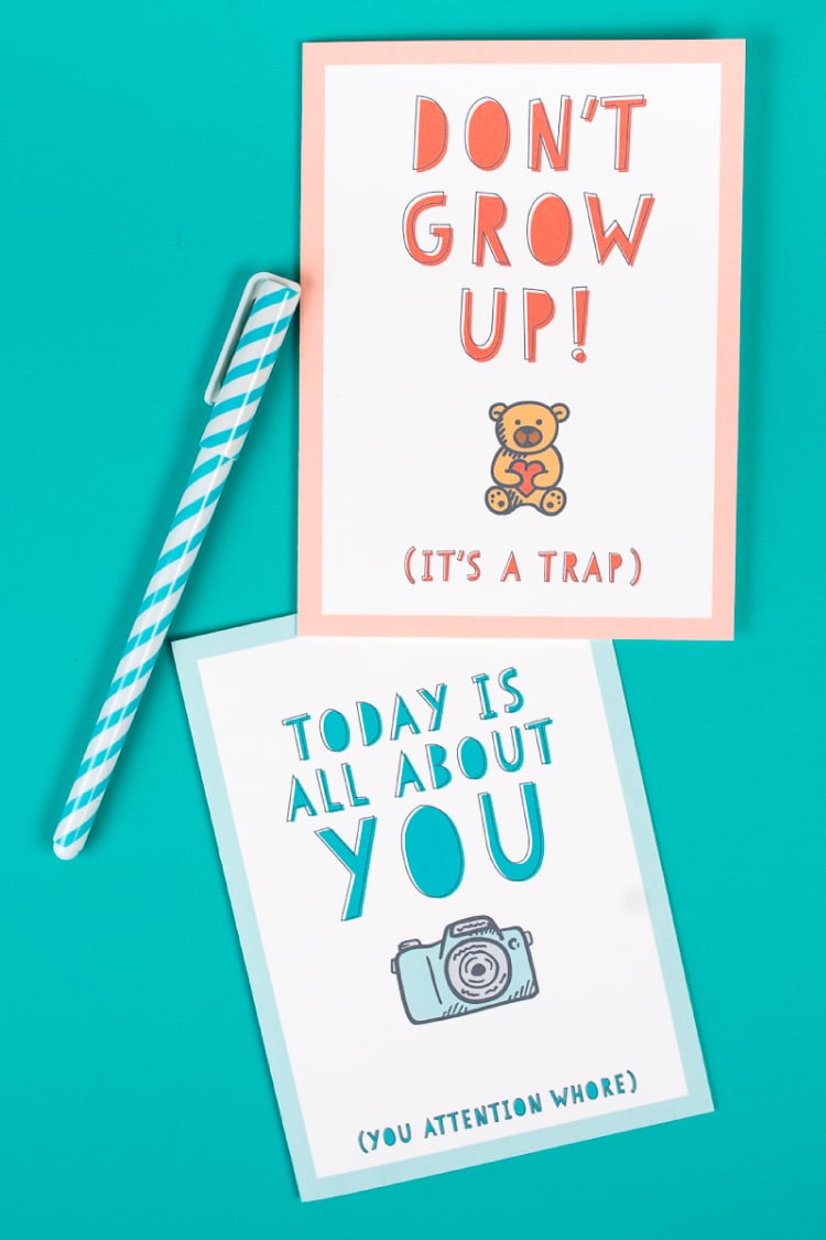 A pen and two birthday cards that say, \"Today is all About You,\" and \"Don\'t Grow Up! It\'s a Trap\"