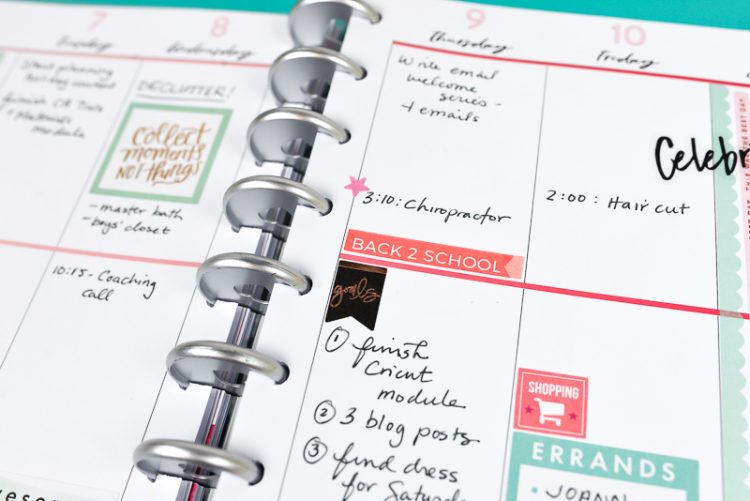 A close up of a weekly planner with stickers