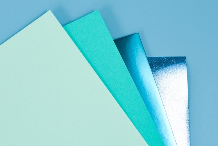 Four pieces of paper in different hues of blue