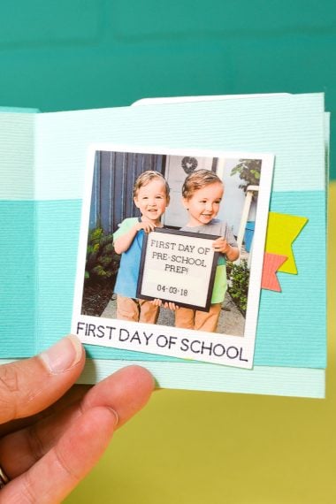 A hand holding a back-to-school memory book