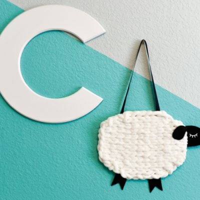 The letter "C" and A yarn and felt sheep hanging on a wall