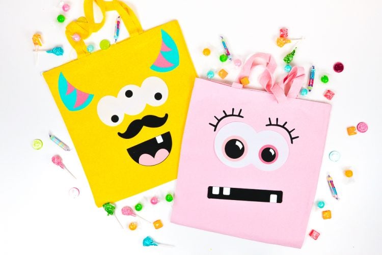 Pieces of candy around a yellow and a pink bag both decorated with funny faces