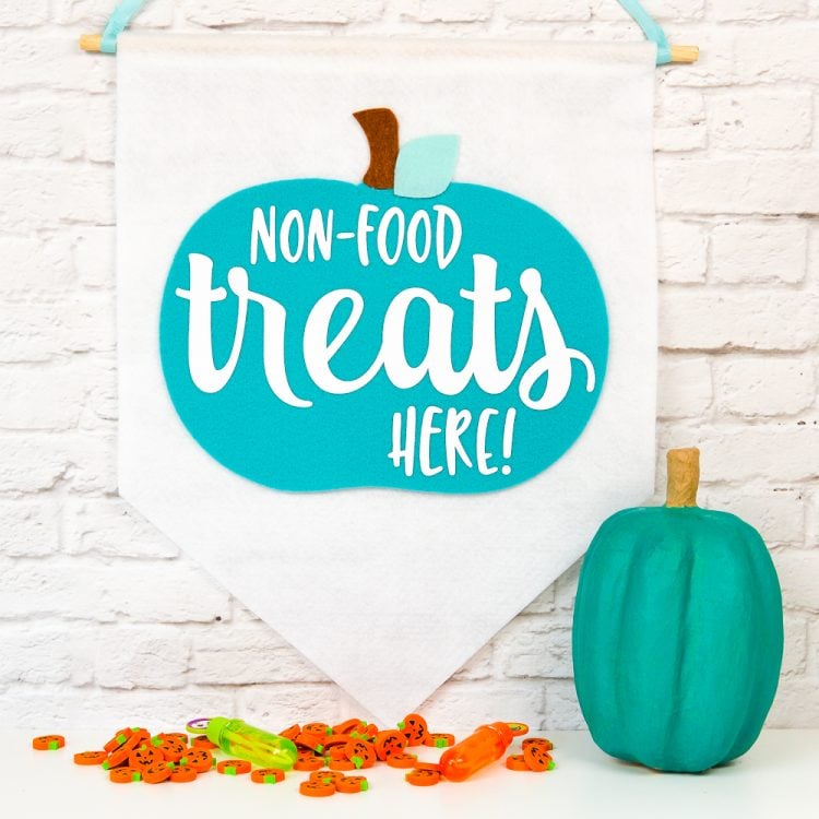 Teal pumpkin next to a hanging banner that says, \"Non-Food Treats Hear!\"