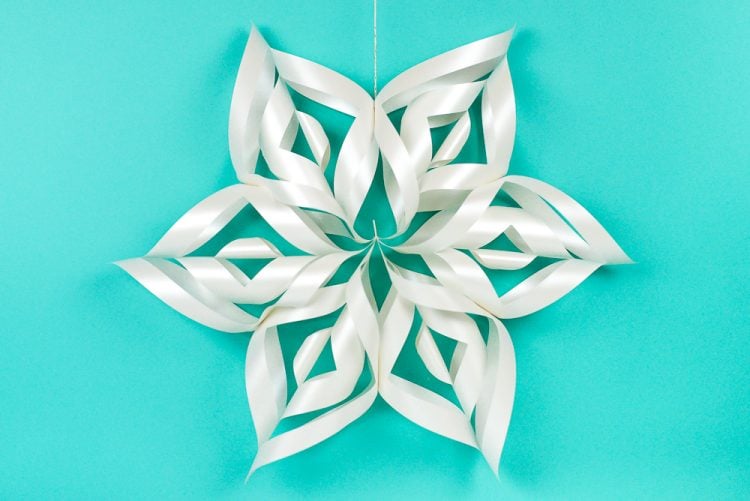 These giant 3D paper snowflakes are fun, whimsical, and will transform your next holiday party into a winter wonderland! Even better, you can cut them using your Cricut and assemble them in minutes.