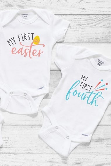 Two white onesies, one designed with an Easter egg and the words, "My First Easter" and the other one with fireworks and the words, "My First Fourth"