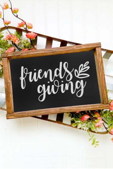 Flowers surrounding a "Friends Giving" sign in a wooden frame