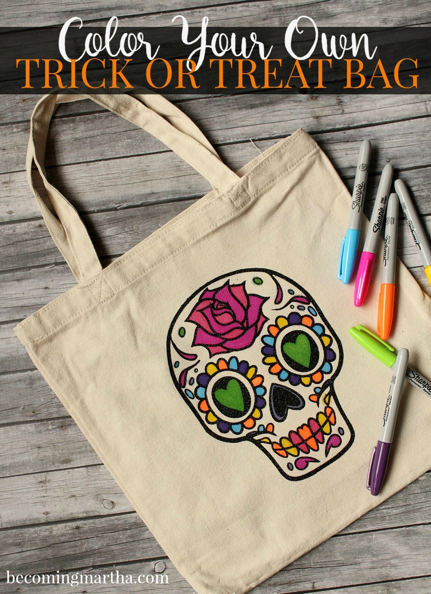 Some markers on top of a canvas tote bag that is decorated with a sugar skull