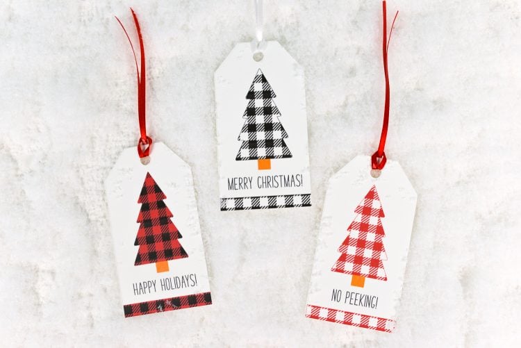 Three Christmas gift tags decorated with sayings and buffalo plaid Christmas trees