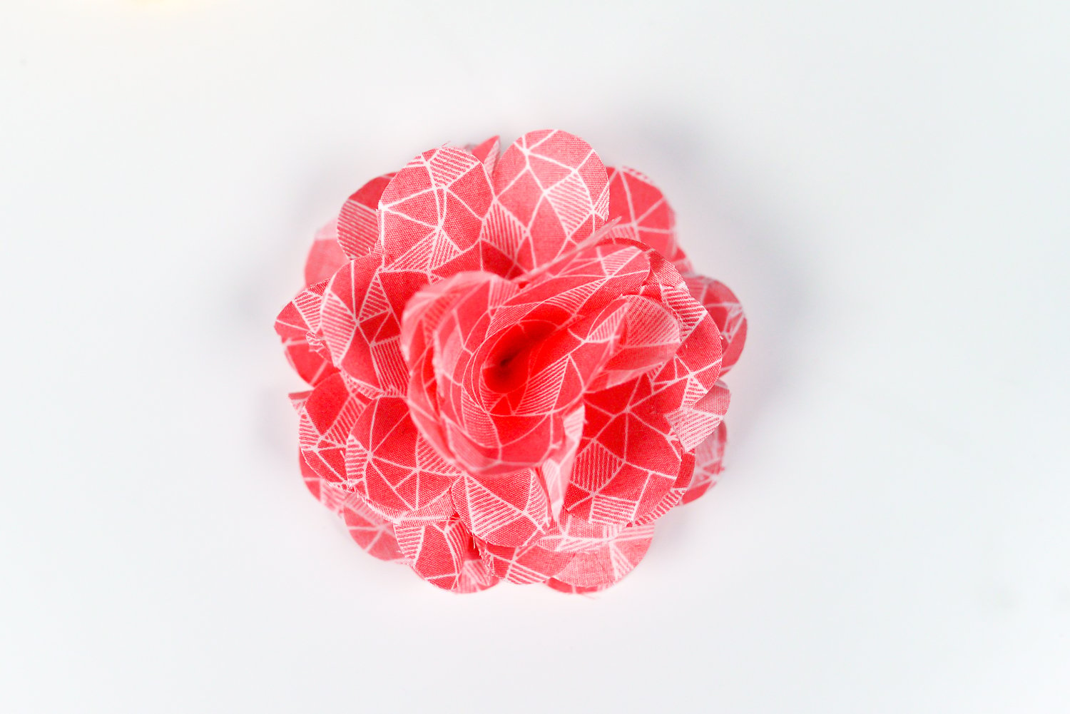 A close up of a pink paper cut out flower