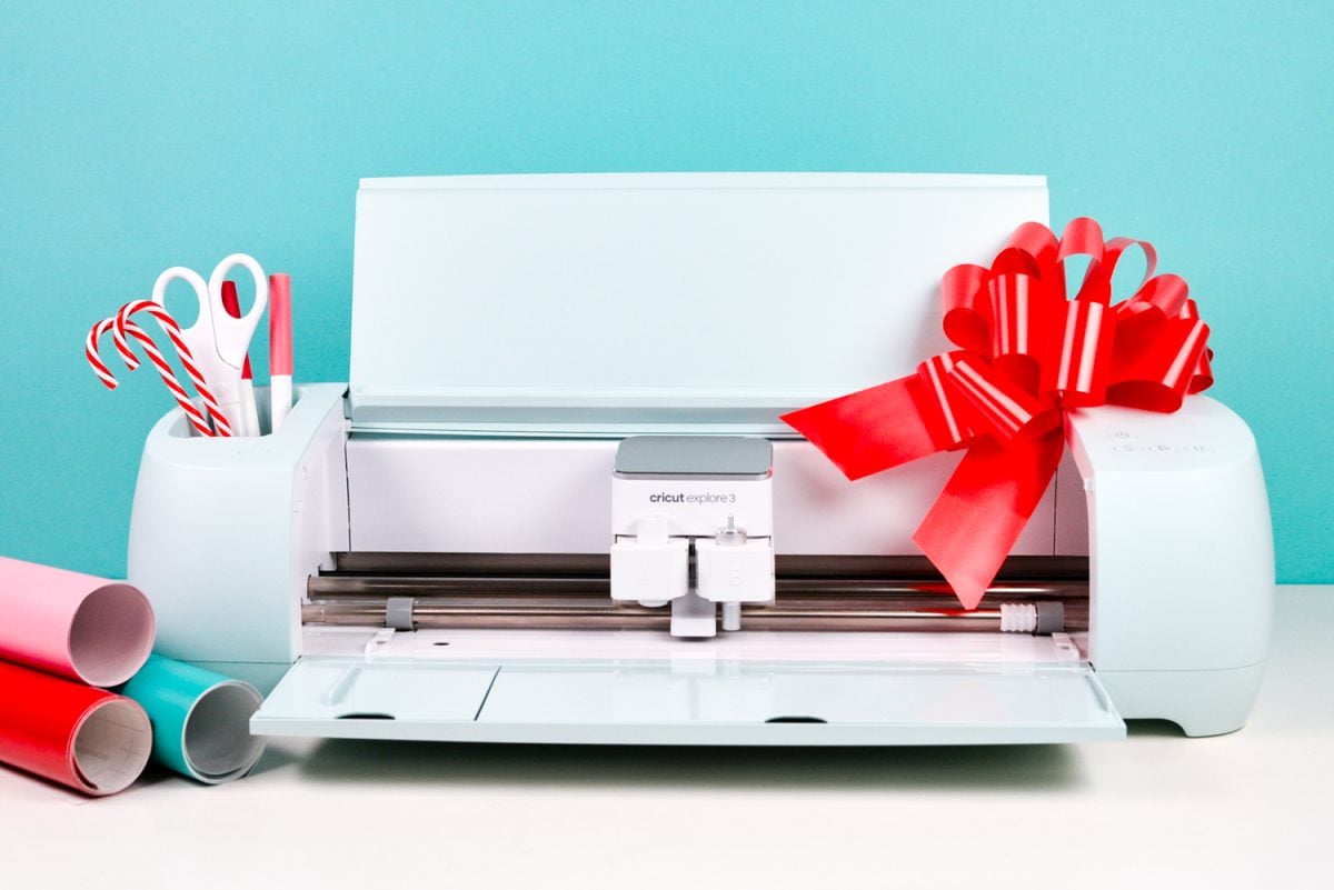 Cricut Explore 3 with holiday accessories and bow.