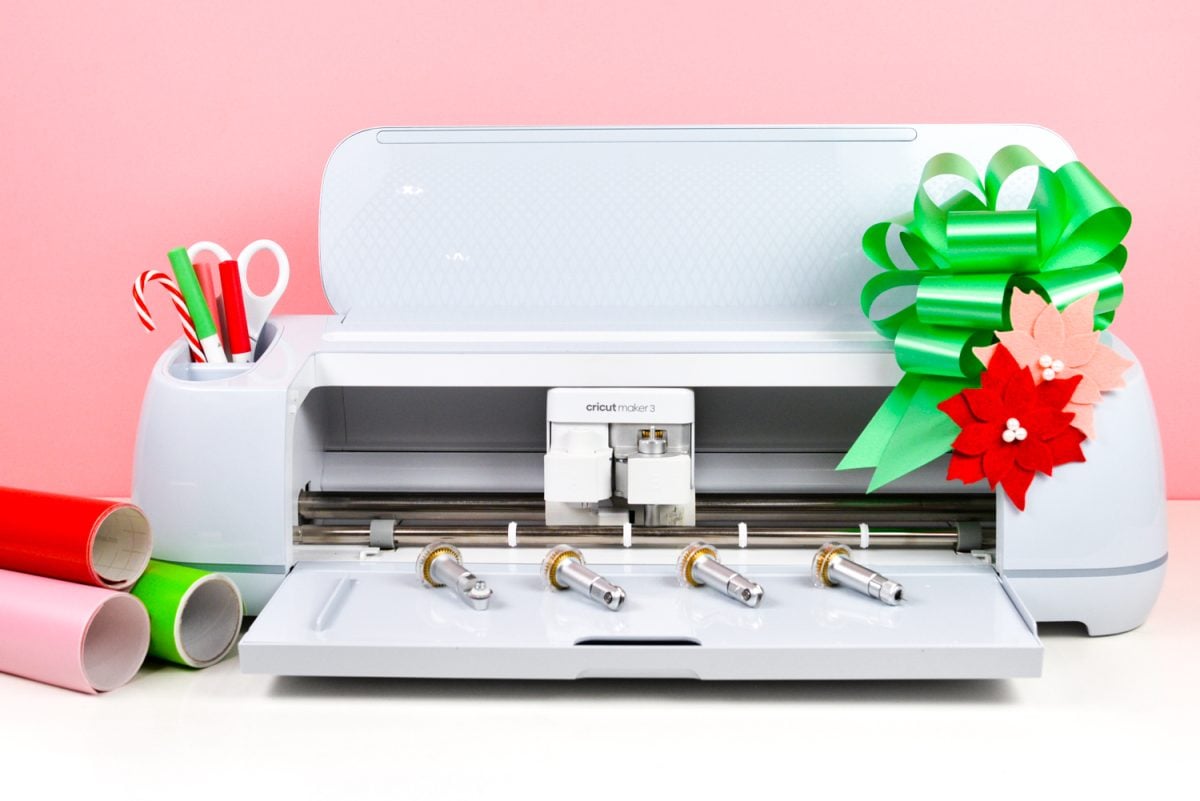 Cricut Maker 3 with holiday accessories and bow.