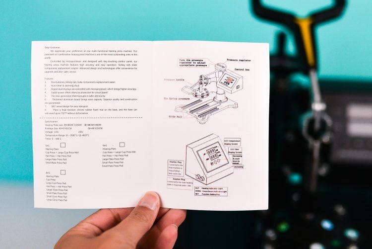 A hand holding instructions for using a heat press