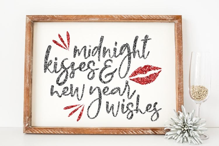 Close of a \"Midnight Kisses & New Year Wishes\" design in a wooden frame 