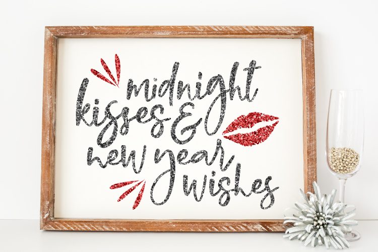 Close of a \"Midnight Kisses & New Year Wishes\" design in a wooden frame 