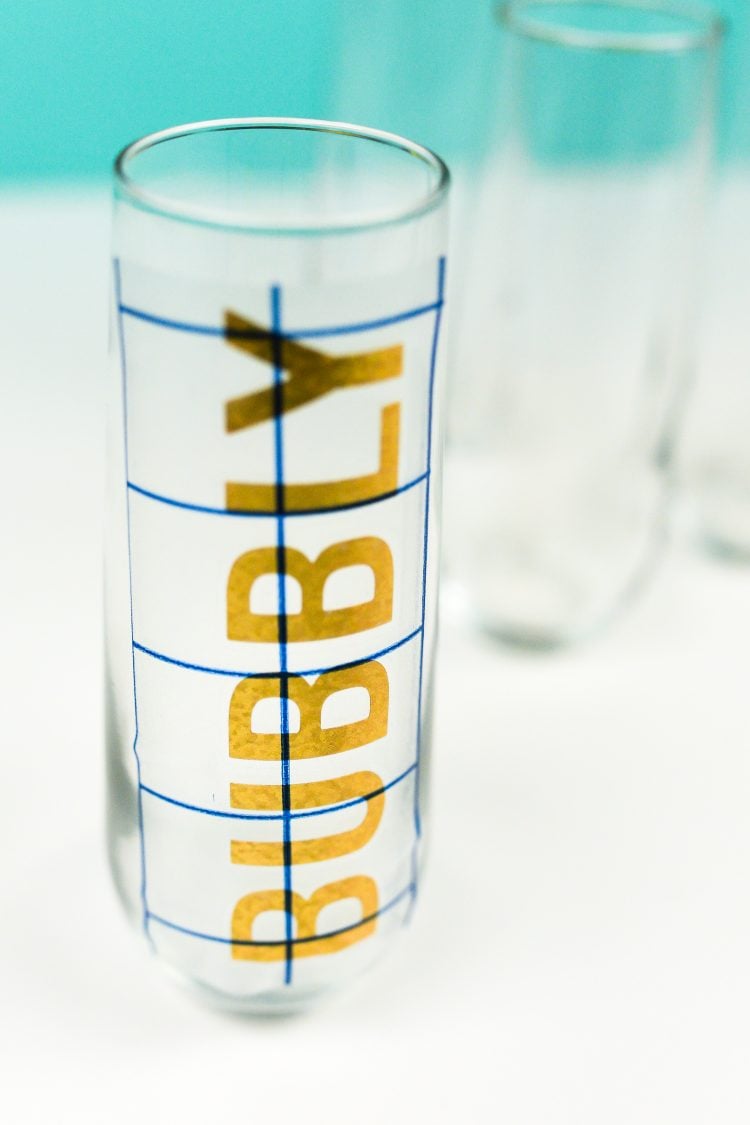 A close up of a glass with \"Bubbly\" decal attached