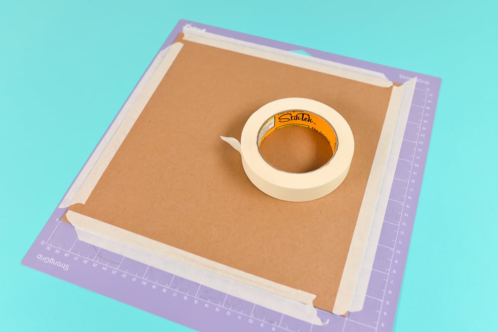Use masking tape to secure your chipboard to the mat