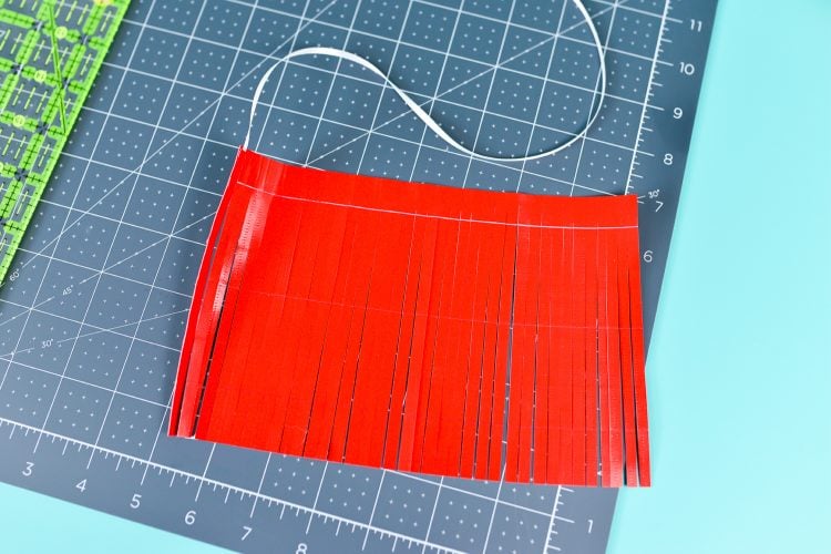 Red material on a gray mat that is cut in strips