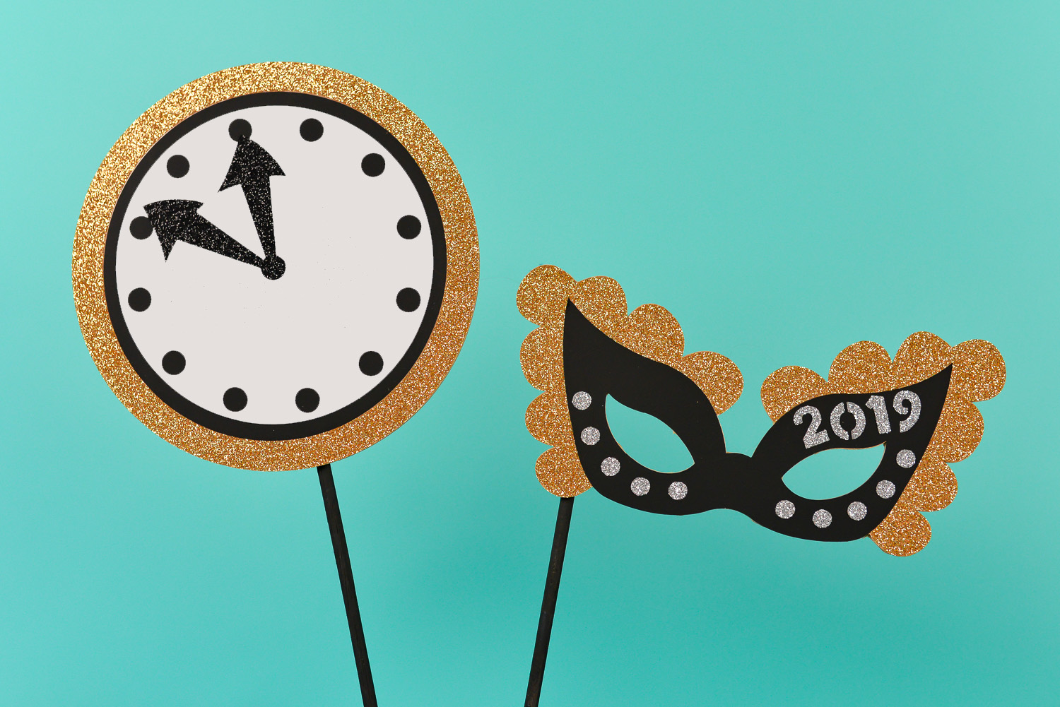 New Year\'s Eve photo booth props made from chipboard of a clock and a mask