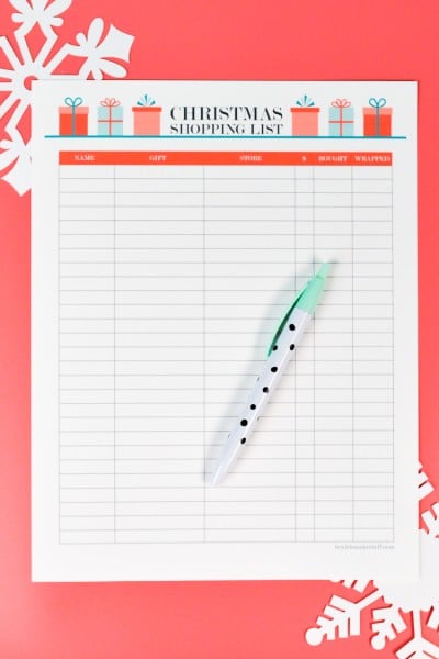 A pen lying on top of a piece of paper that is a Christmas Shopping List