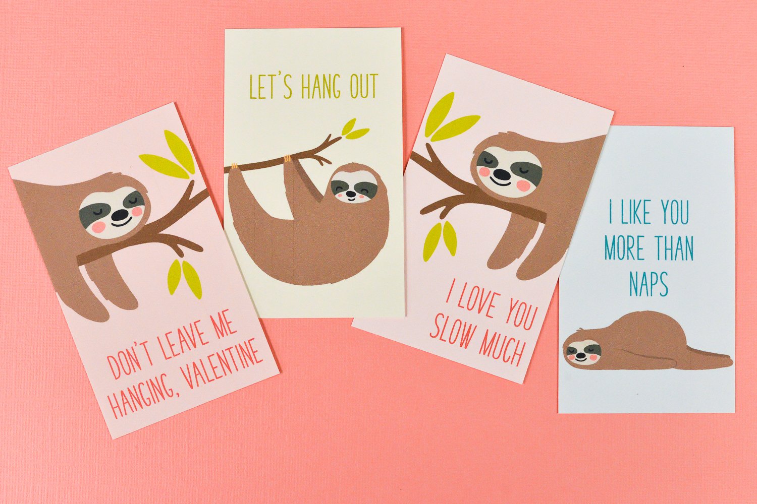 Close up of four cards with images of a sloth on each one and the following sayings, \"Don\'t Leave Me Hanging, Valentine\", \"I Love You More Than Naps\", Let\'s Hang Out\" and \"I Love You Slow Much\"