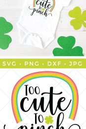 Green shamrocks around a white onesie that is decorated with a rainbow and the saying, "Too Cute to Pinch" and a cut file of the design advertised by HEYLETSMAKESTUFF.COM