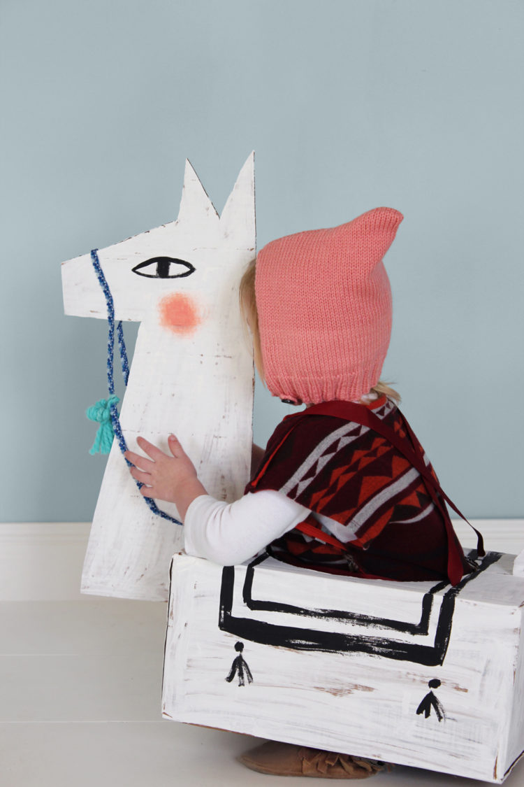 A child wearing a cardboard llama costume