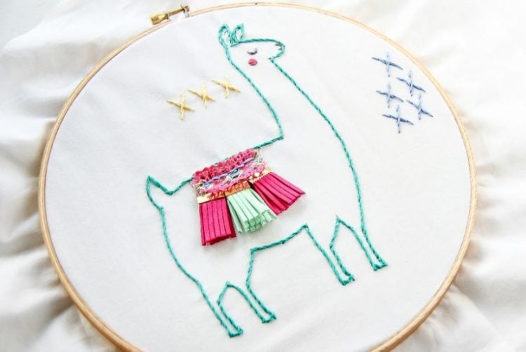 An embroidery hoop with a llama embroidery pattern