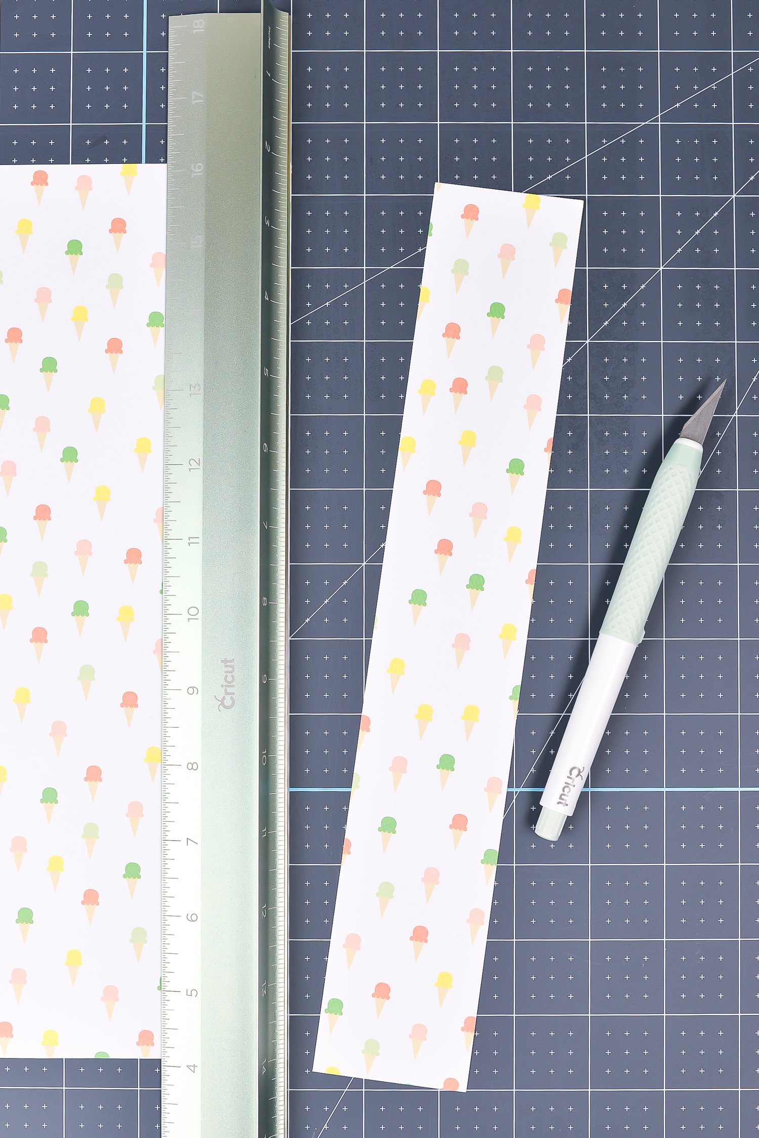 Close up of the Cricut True Control Knife, a cutting ruler and a piece of fabric on top of the Cricut self-healing mat