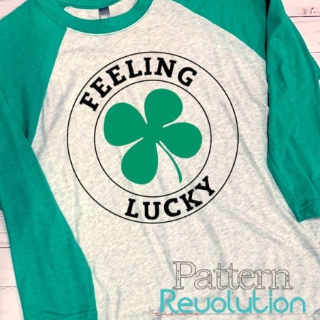 Gray and green t-shirt that has an image of a shamrock on it and the words Feeling Lucky
