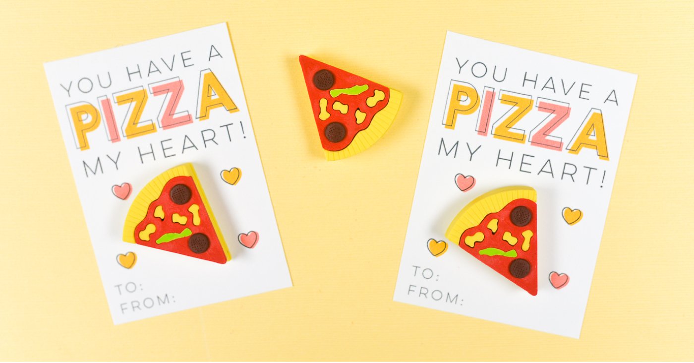 A close up of two Valentine\'s Day cards with a piece of fake pizza on them and the saying, 
\"You Have a Pizza My Heart\"