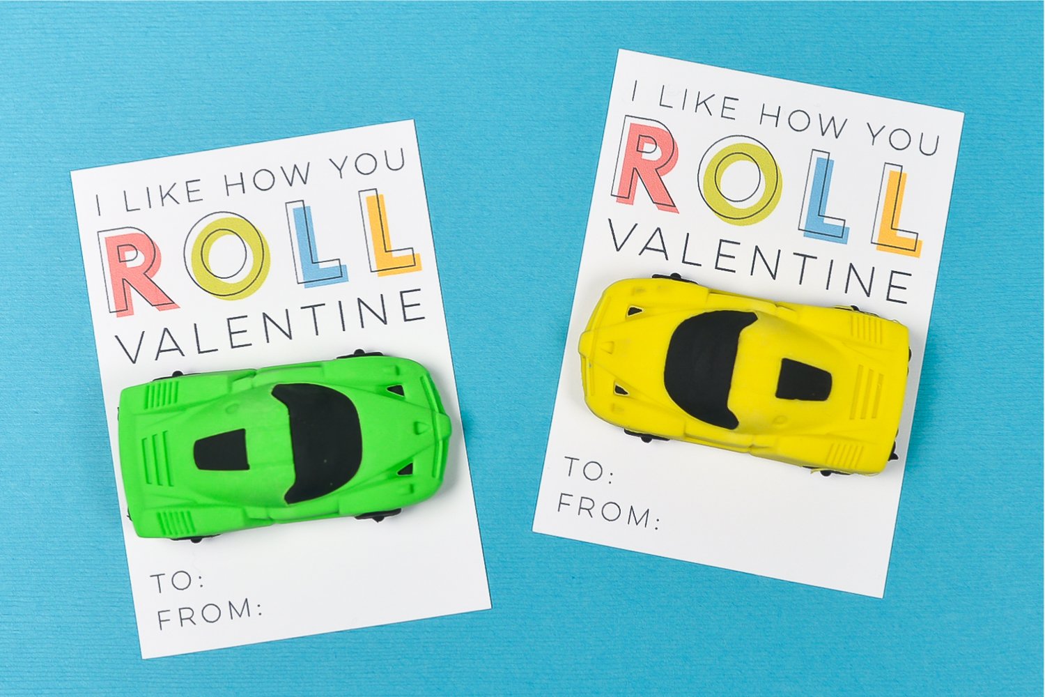 A close up of two Valentine cards, one with a yellow toy car attached to it and the other one with a green toy car and both say, \"I Like How You Roll Valentine\"