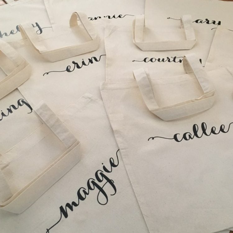 Several white canvas totes personalized with names